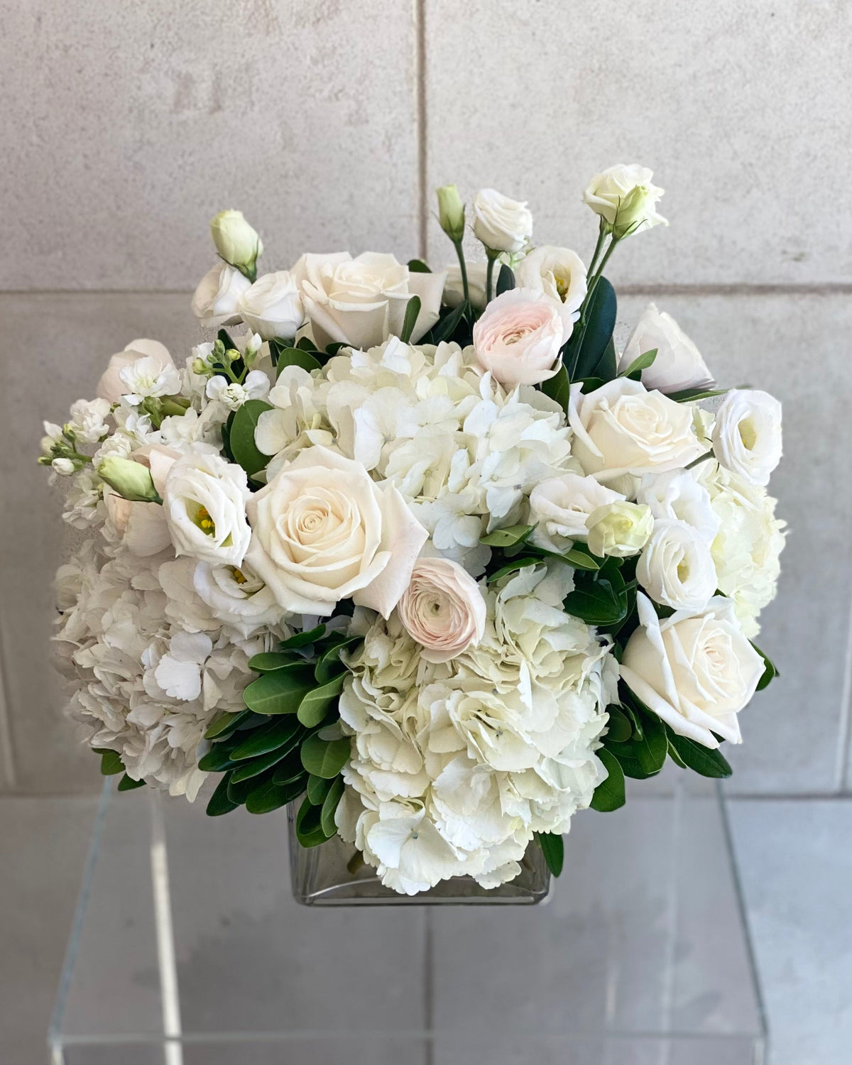 Blush and white vase arrangement with seasonal flowers in soft pink, cream, and white tones.