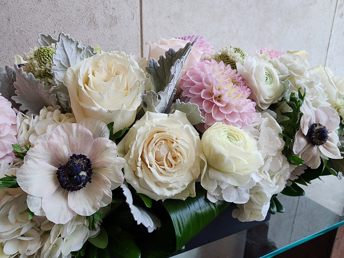 Custom floral arrangement created with a curated selection of fresh seasonal flowers and greenery.