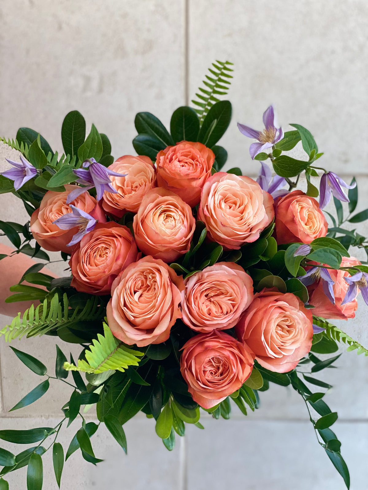 Dozen roses with seasonal accent flowers and fresh greenery, available as a hand-tied bouquet or vase arrangement.