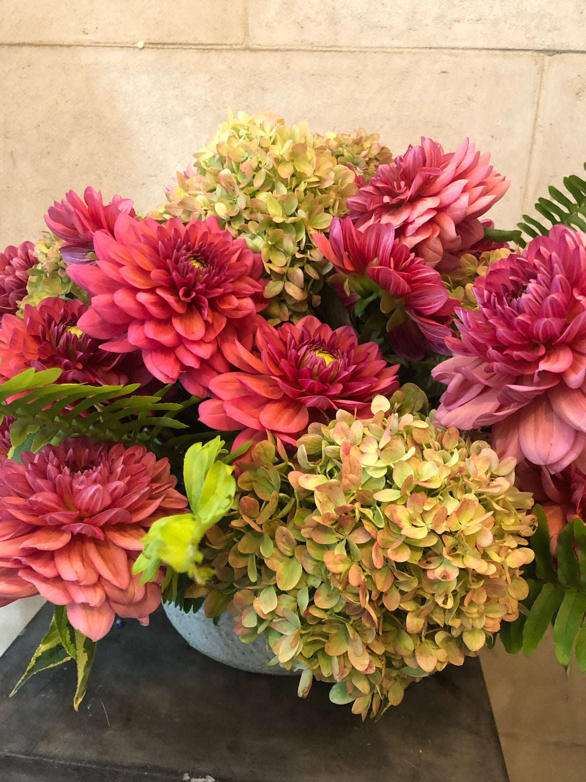 Hydrangea and dahlia vase arrangement in blush, coral, berry and green tones.